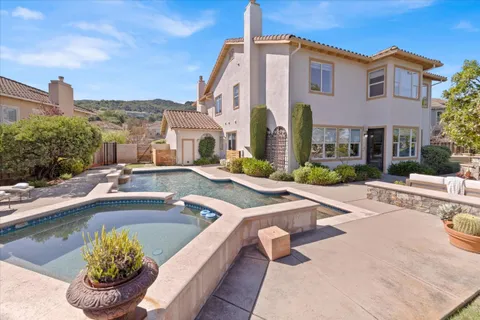 a front view of a house with swimming pool garden and patio