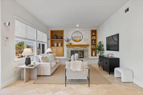 a living room with furniture a flat screen tv and a fireplace