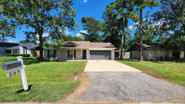 a front view of a house with a yard and trees