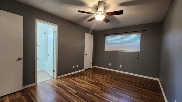 a view of room with window ceiling fan and hardwood floor