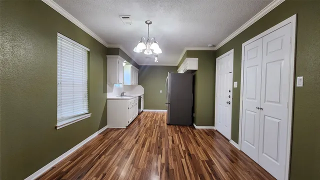 a view of a room with wooden floor and chandelier