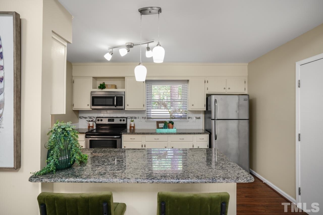 7016 Ray Road Raleigh, NC 27613 - Photo 3 of 26 a kitchen with stainless steel appliances granite countertop a refrigerator a stove a microwave oven a sink and a counter space