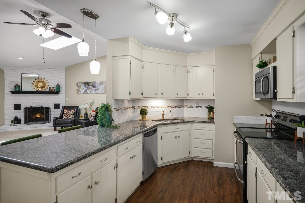 7016 Ray Road Raleigh, NC 27613 - Photo 5 of 26 a kitchen with granite countertop a sink stainless steel appliances and cabinets