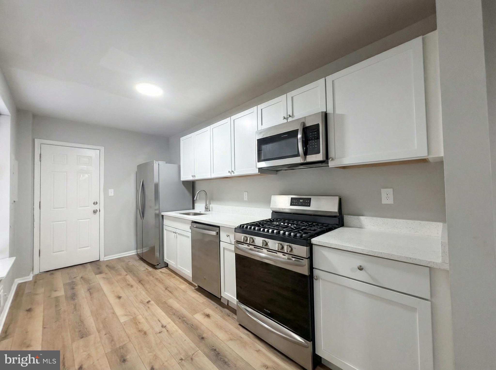 411 North Chester Street Baltimore, MD 21231 - Photo 3 of 22 a kitchen with a stove microwave and sink