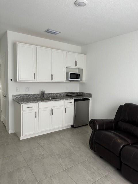 5133 Armina Place, Unit STUDIO Fort Pierce, FL 34951 - Photo 5 of 15 a kitchen with granite countertop white cabinets and stainless steel appliances