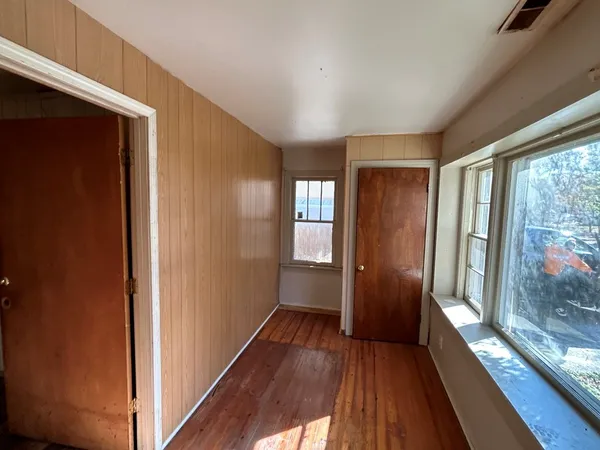a view of hallway with a large window and wooden floor