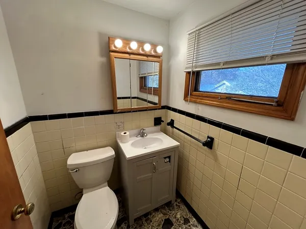 a bathroom with a toilet sink and mirror