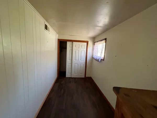 a view of a hallway with wooden floor and windows