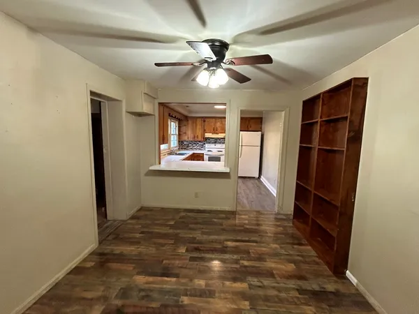 a view of a livingroom with a furniture ceiling fan and hardwood floor
