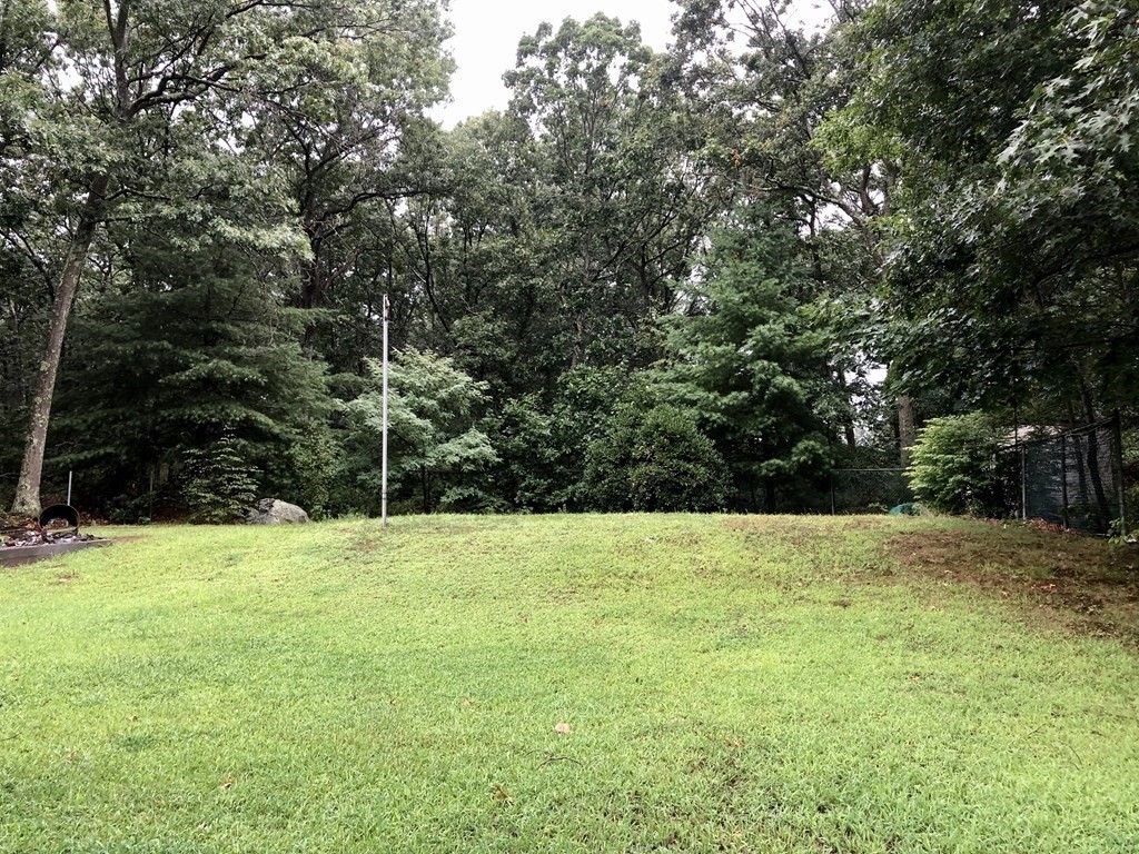69 Deerfield Road Sharon, MA 02067 - Photo 9 of 12 a view of grassy field with trees in the background