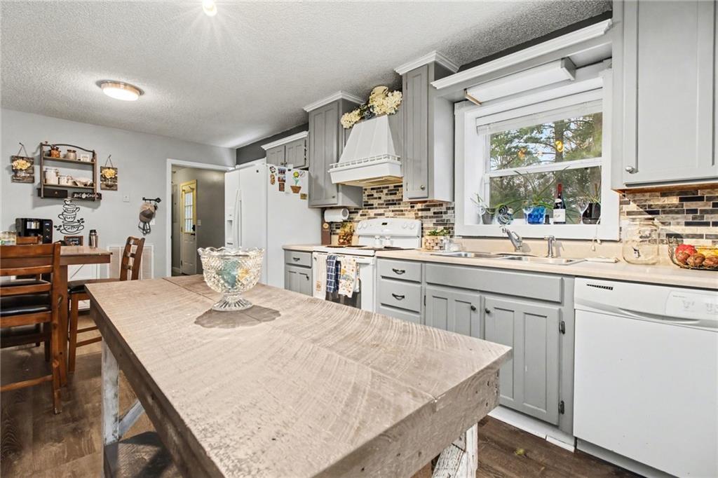 1932 River Bend Road Southwest Plainville, GA 30733 - Photo 12 of 30 a kitchen with a stove a sink dishwasher and a refrigerator with wooden floor