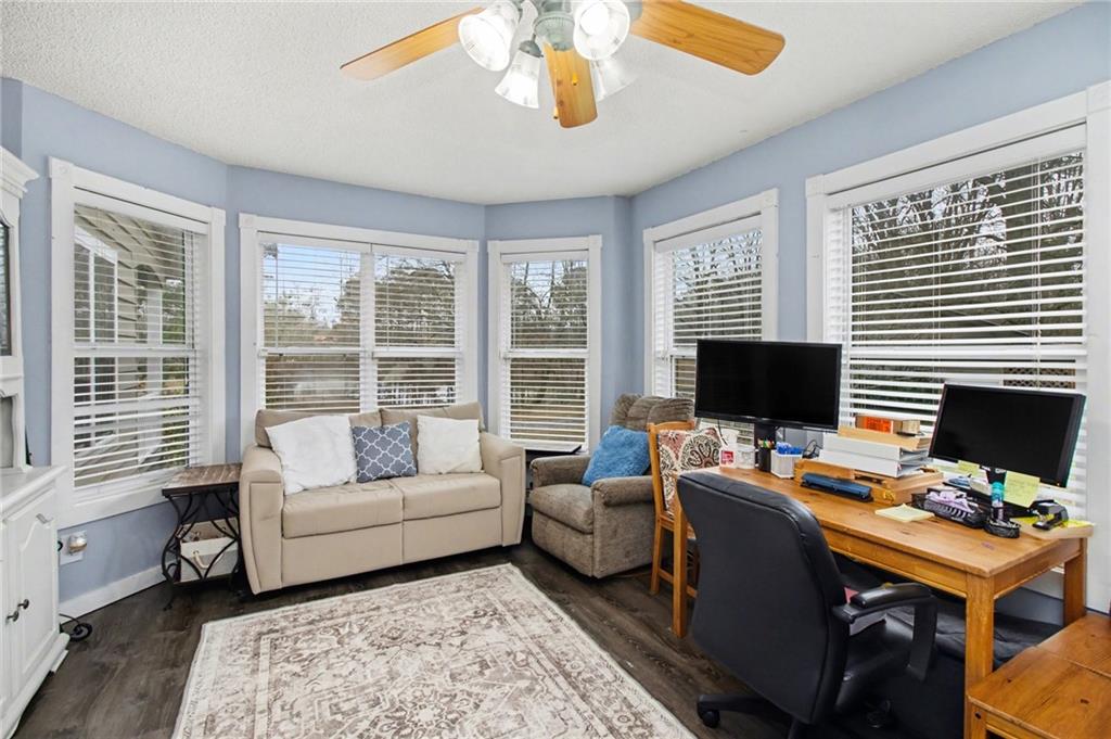 1932 River Bend Road Southwest Plainville, GA 30733 - Photo 15 of 30 a living room with furniture a flat screen tv and a floor to ceiling window