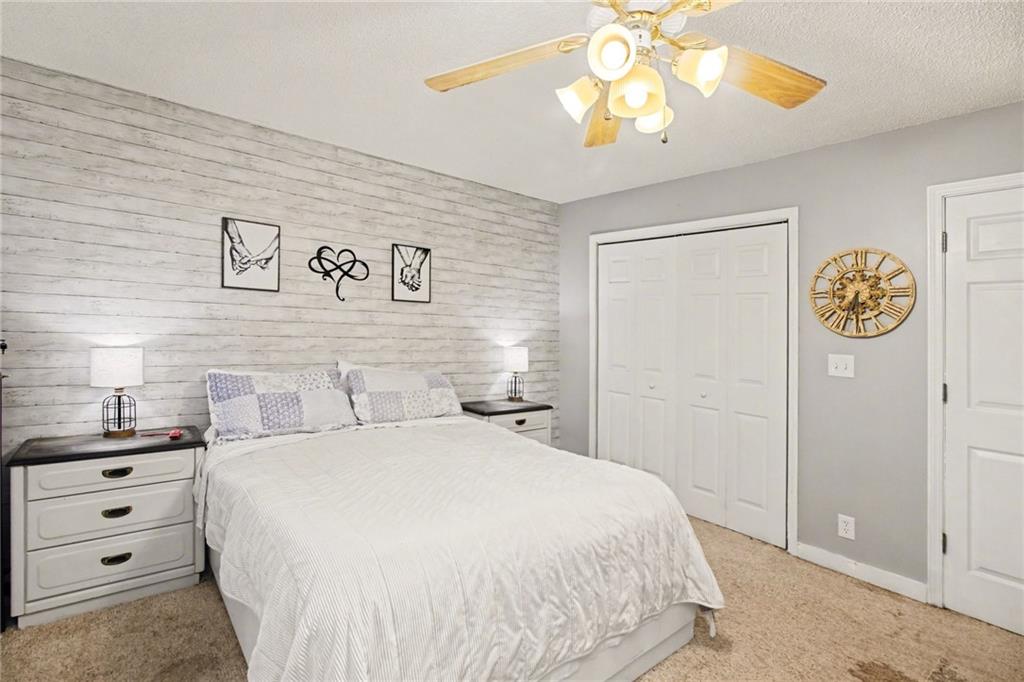 1932 River Bend Road Southwest Plainville, GA 30733 - Photo 17 of 30 a bedroom with a bed and a chandelier