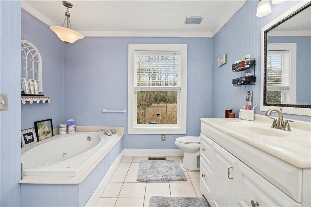 1932 River Bend Road Southwest Plainville, GA 30733 - Photo 21 of 30 a bathroom with a tub a sink and a large mirror