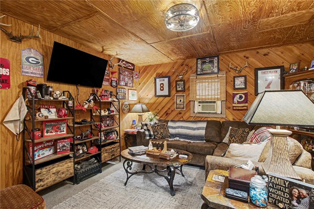 1932 River Bend Road Southwest Plainville, GA 30733 - Photo 25 of 30 a living room with furniture a flat screen tv and a wall painting
