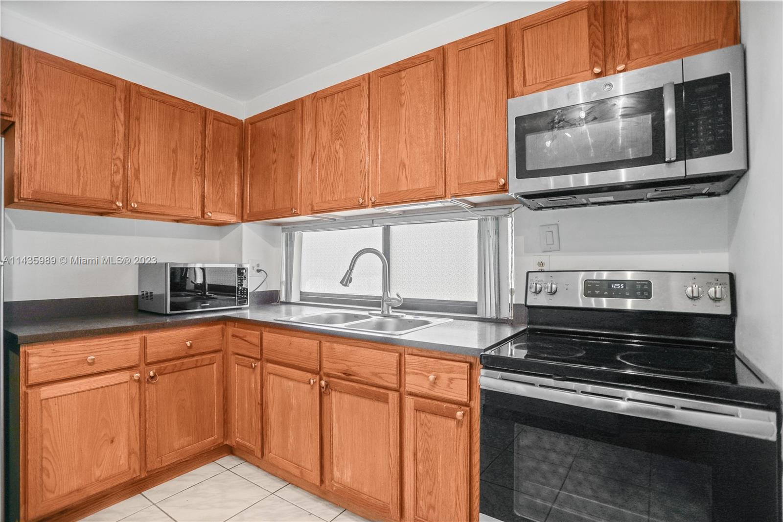 17021 North Bay Road, Unit 418 Sunny Isles Beach, FL 33160 - Photo 23 of 43 a kitchen with stainless steel appliances granite countertop a stove microwave and sink
