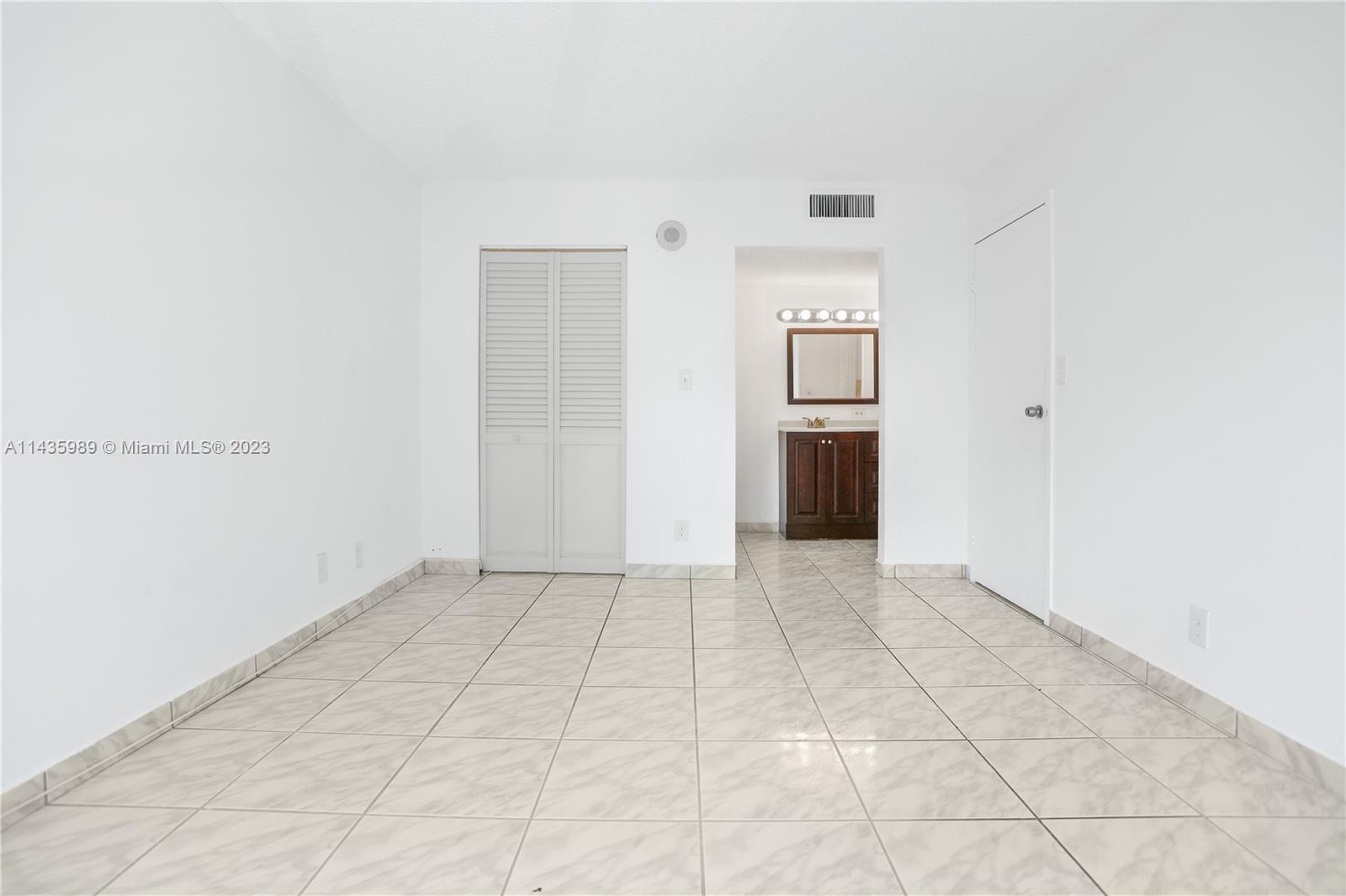 17021 North Bay Road, Unit 418 Sunny Isles Beach, FL 33160 - Photo 27 of 43 a view of an empty room with wooden floor and kitchen