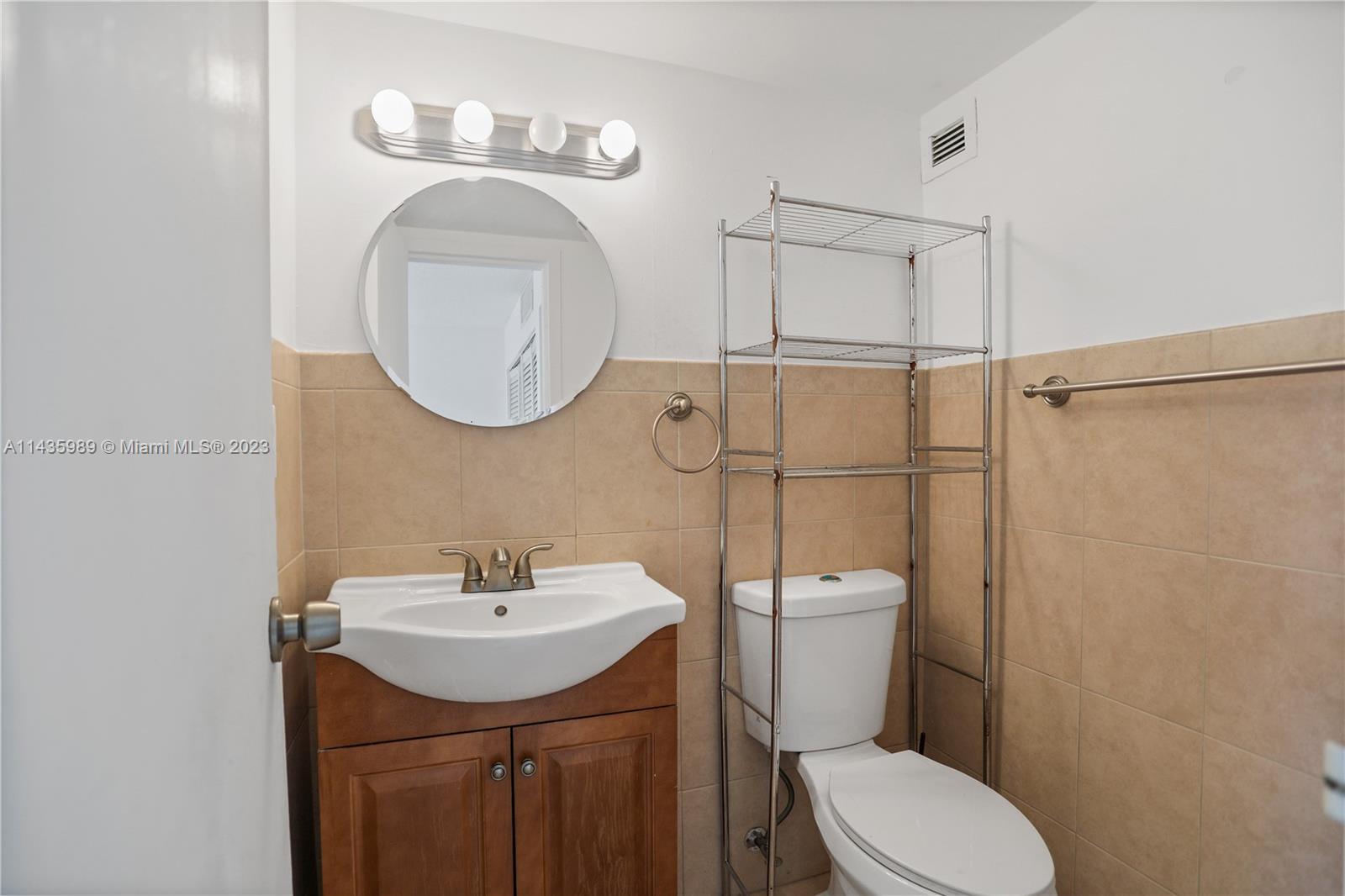 17021 North Bay Road, Unit 418 Sunny Isles Beach, FL 33160 - Photo 28 of 43 a bathroom with a toilet a sink and mirror