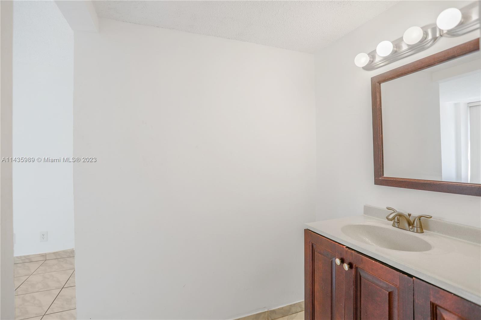 17021 North Bay Road, Unit 418 Sunny Isles Beach, FL 33160 - Photo 30 of 43 a bathroom with a sink and a mirror