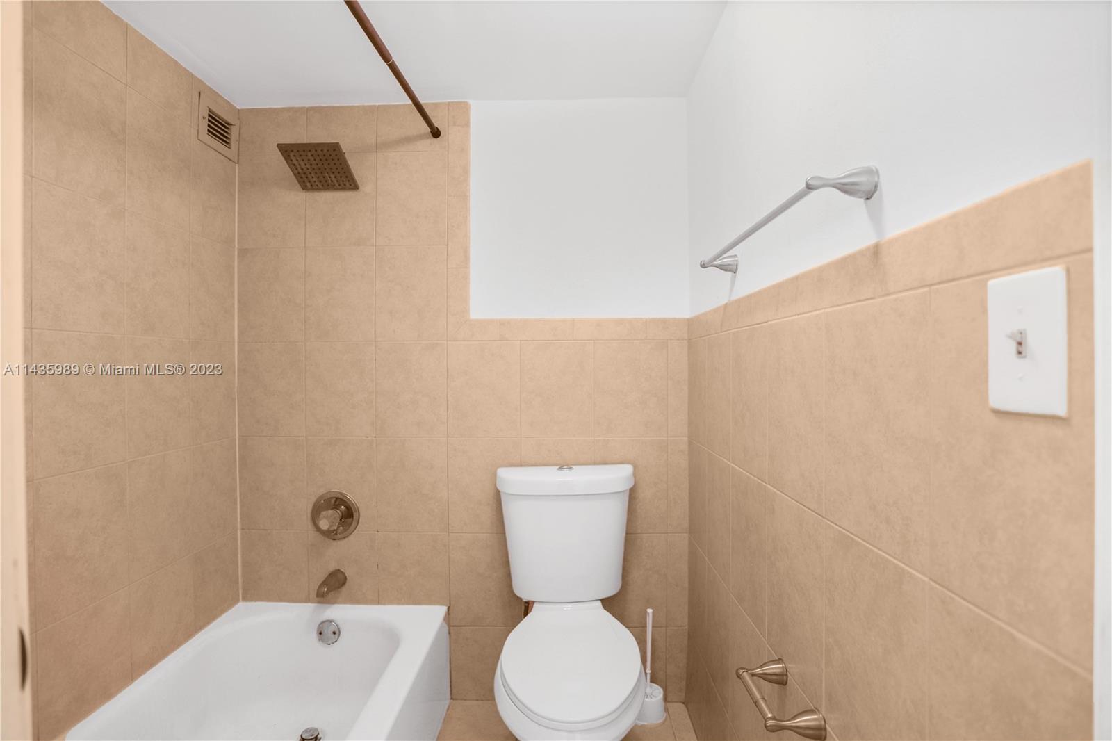 17021 North Bay Road, Unit 418 Sunny Isles Beach, FL 33160 - Photo 31 of 43 a bathroom with a toilet and a shower curtain