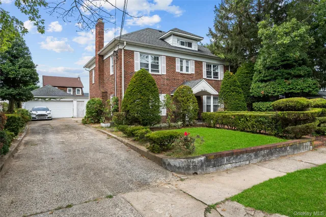 a front view of a house with a yard and potted plants