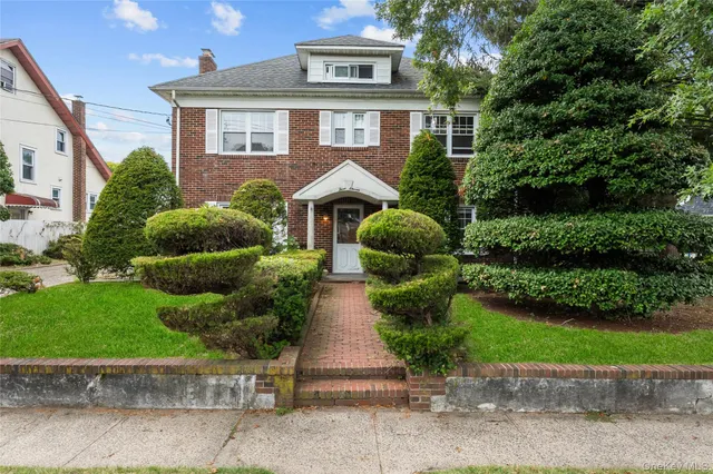 a front view of a house with a garden