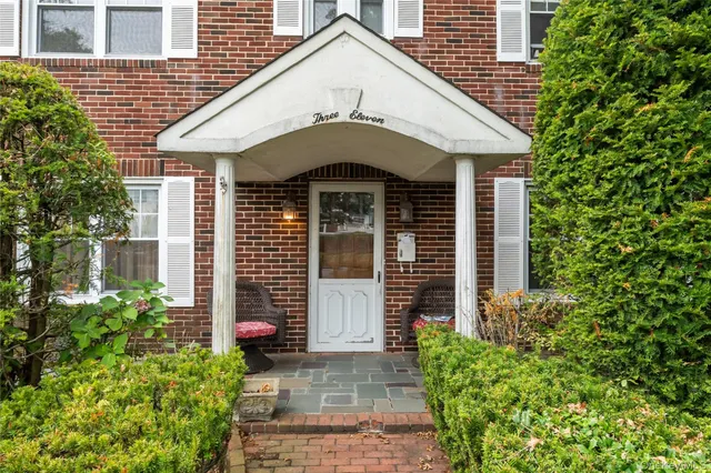 a front view of a house with a yard and plants