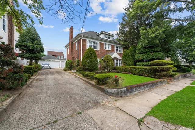 a view of a white house with a yard and potted plants