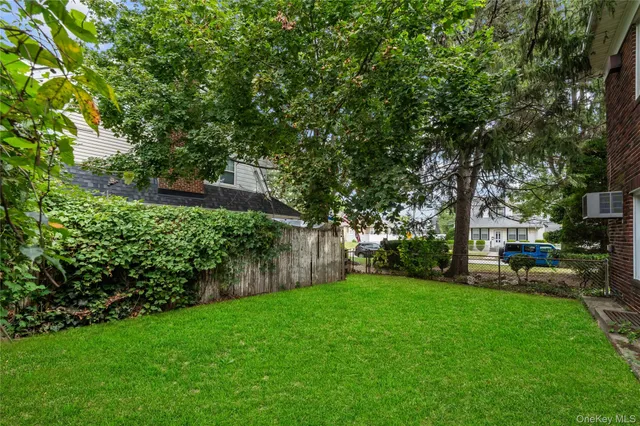 a view of a backyard with table and chairs and a tree