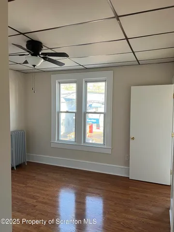 a view of a livingroom with wooden floor and windows