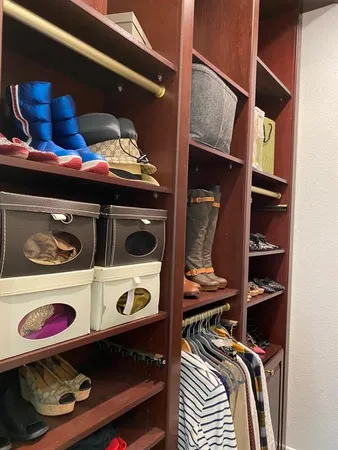 a view of walk in closet with clothes and shoes