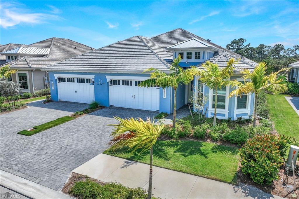 6895 Saona Court Naples, FL 34113 - Photo 1 of 33 a front view of a house with a garden