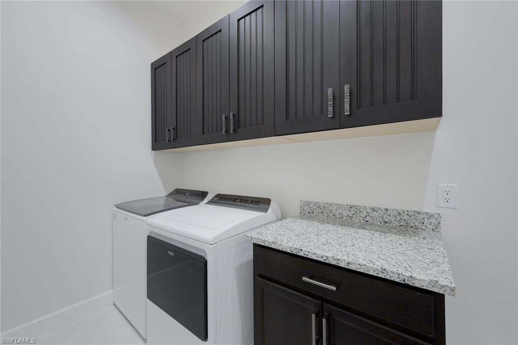 6895 Saona Court Naples, FL 34113 - Photo 14 of 33 a utility room with granite countertop cabinets washer and dryer