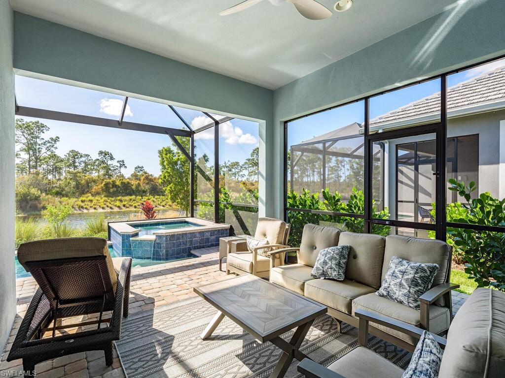 6895 Saona Court Naples, FL 34113 - Photo 16 of 33 a living room with furniture and a floor to ceiling window