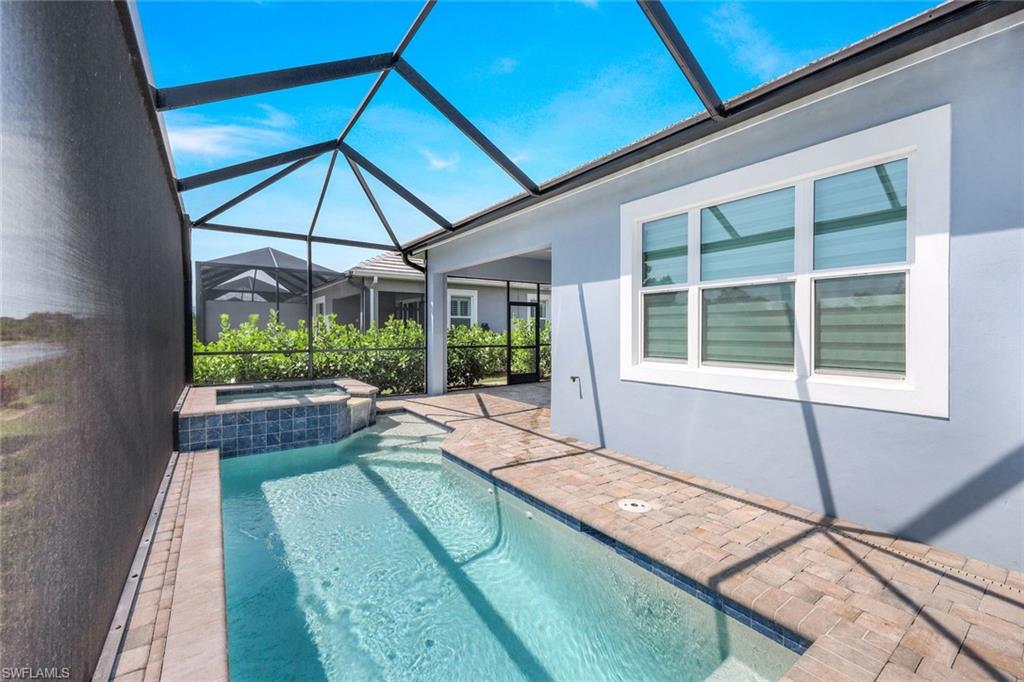 6895 Saona Court Naples, FL 34113 - Photo 19 of 33 a swimming pool with outdoor seating and yard