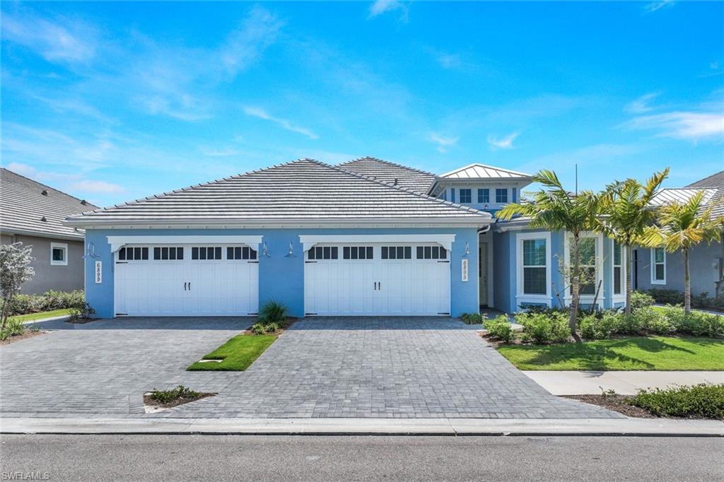 6895 Saona Court Naples, FL 34113 - Photo 2 of 33 a front view of a house with a garden and plants