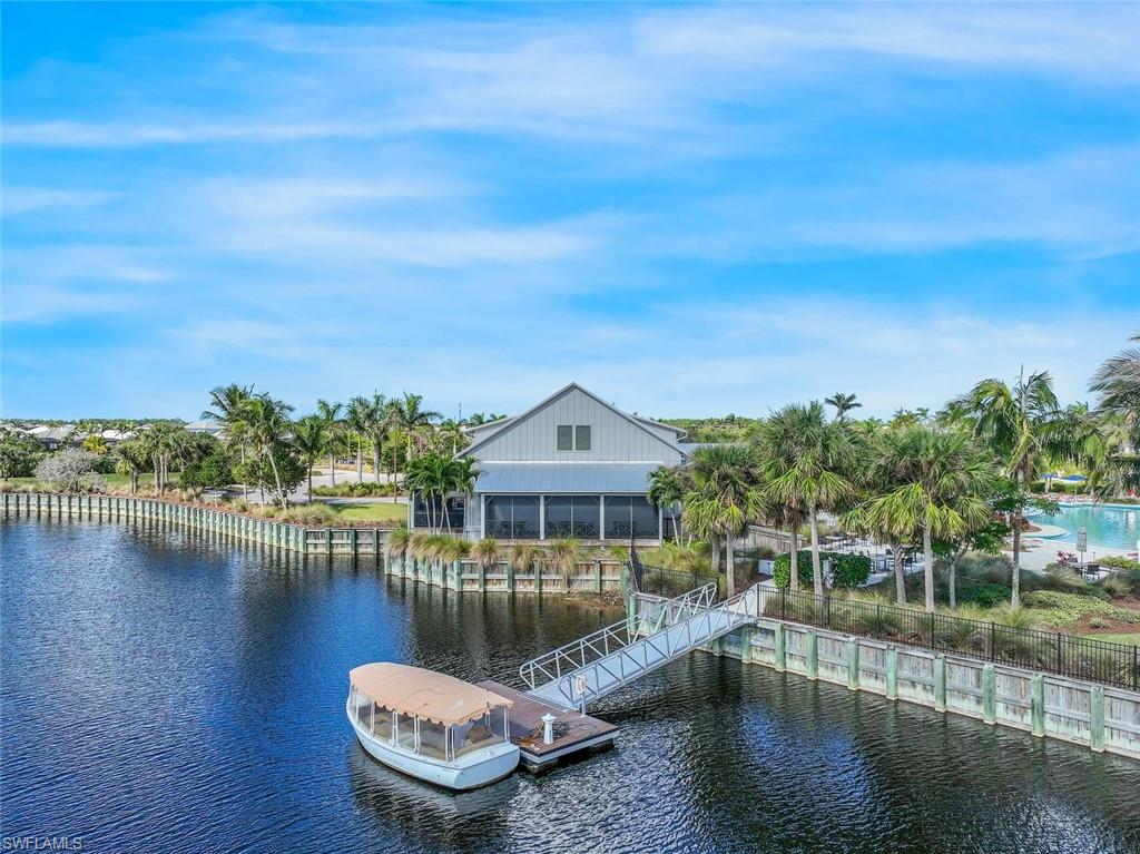 6895 Saona Court Naples, FL 34113 - Photo 26 of 33 a view of a lake with a house in the background