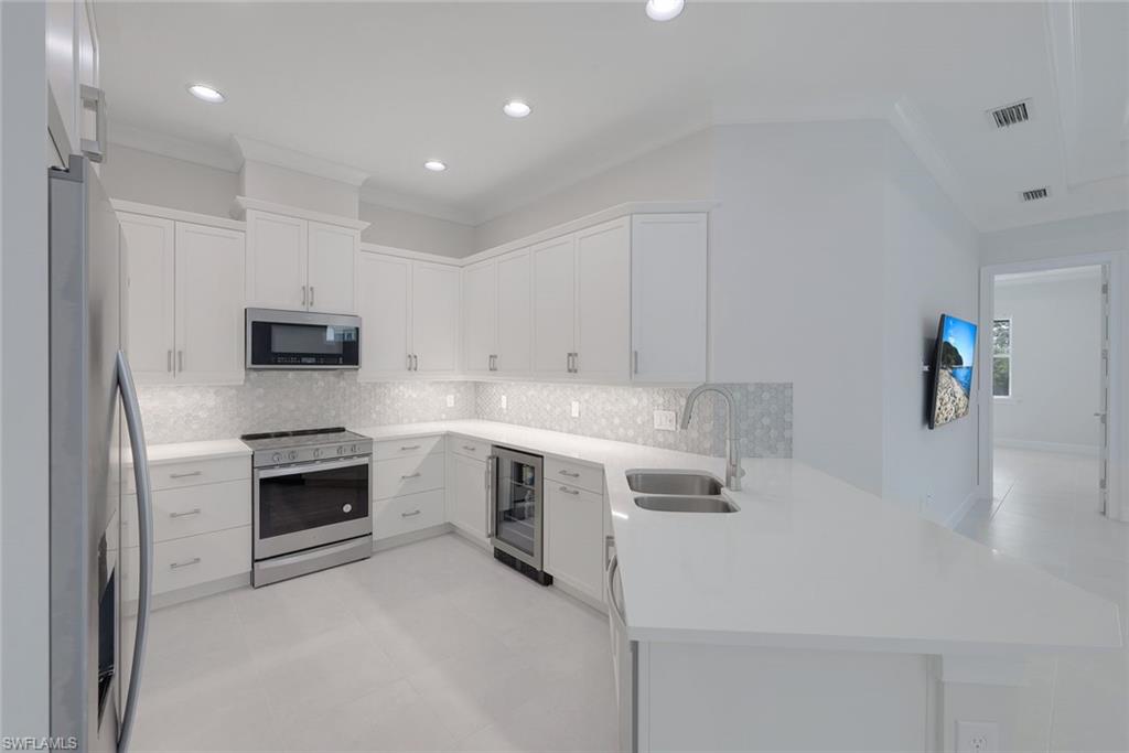 6895 Saona Court Naples, FL 34113 - Photo 3 of 33 a kitchen with a sink stove and microwave