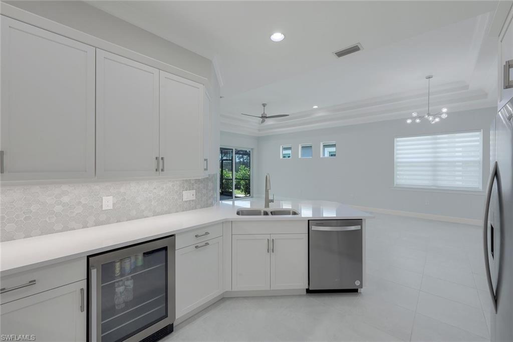 6895 Saona Court Naples, FL 34113 - Photo 4 of 33 a kitchen with a sink stove and cabinets