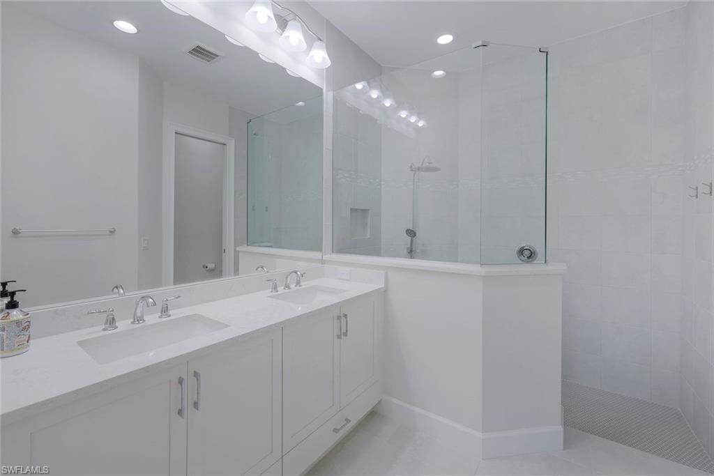 6895 Saona Court Naples, FL 34113 - Photo 9 of 33 a bathroom with a double vanity sink and a mirror