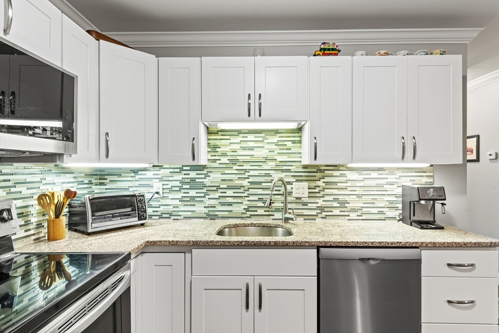 24 Shayne Road, Unit 219 Franklin, MA 02038 - Photo 8 of 23 a kitchen with stainless steel appliances granite countertop a sink and a microwave