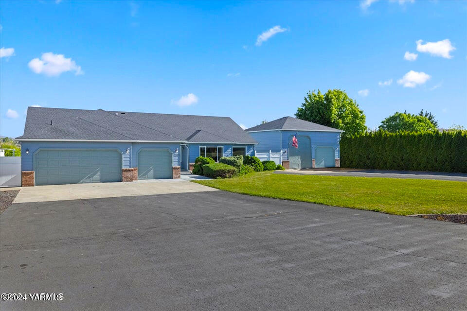 12555 West Barrett Road Yakima, WA 98908 - Photo 1 of 27 a front view of a house with a yard and garage