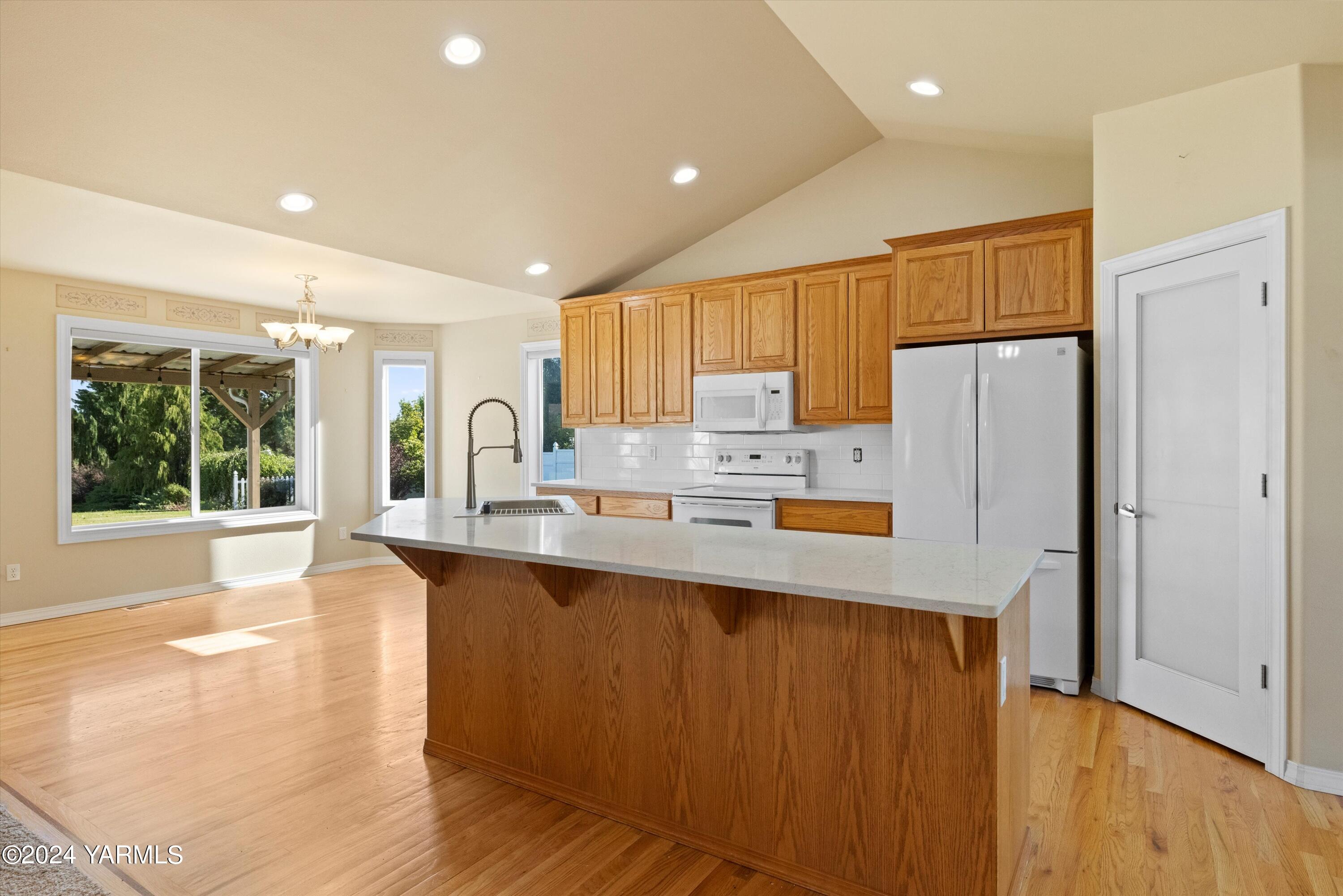 12555 West Barrett Road Yakima, WA 98908 - Photo 7 of 27 a kitchen with stainless steel appliances granite countertop a refrigerator a sink a stove and a refrigerator with wooden floor