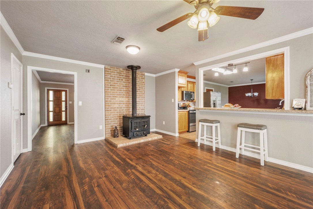 3840 Mancuso Road Bryan, TX 77808 - Photo 6 of 31 a living room with furniture a fireplace and wooden floor