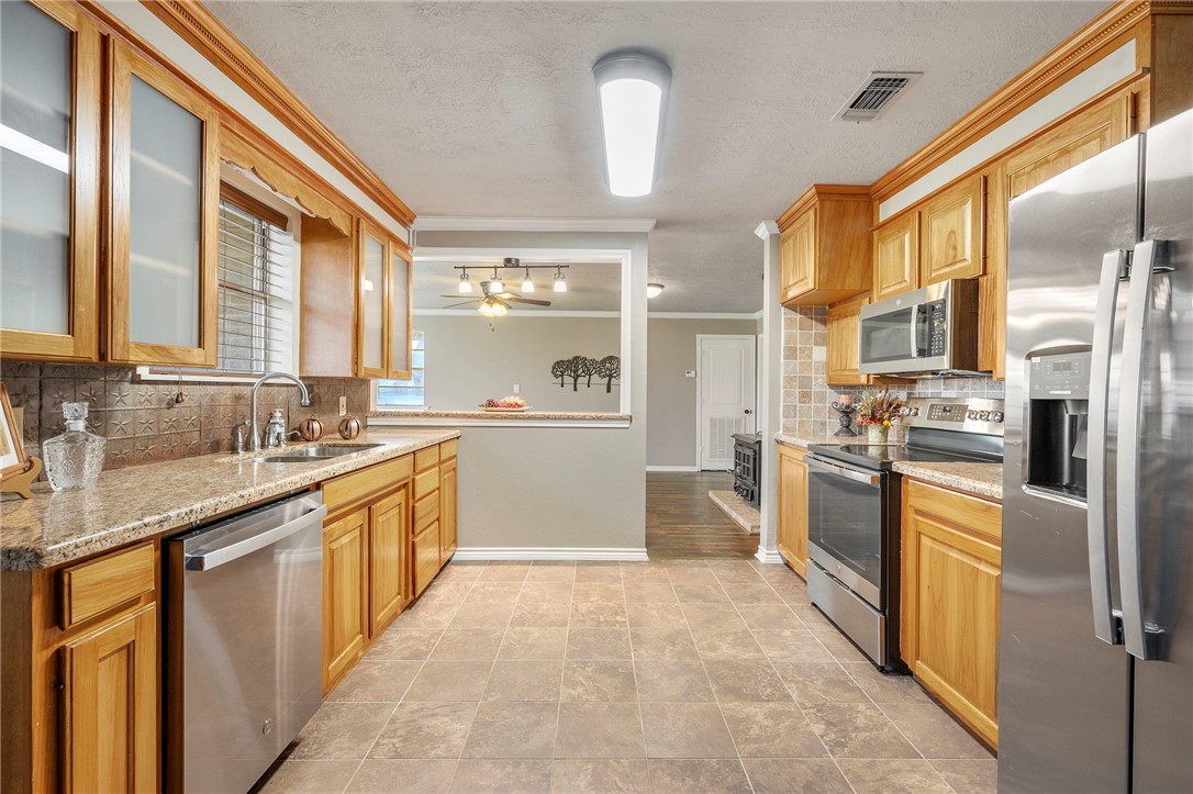 3840 Mancuso Road Bryan, TX 77808 - Photo 7 of 31 a large kitchen with stainless steel appliances granite countertop a refrigerator and a sink