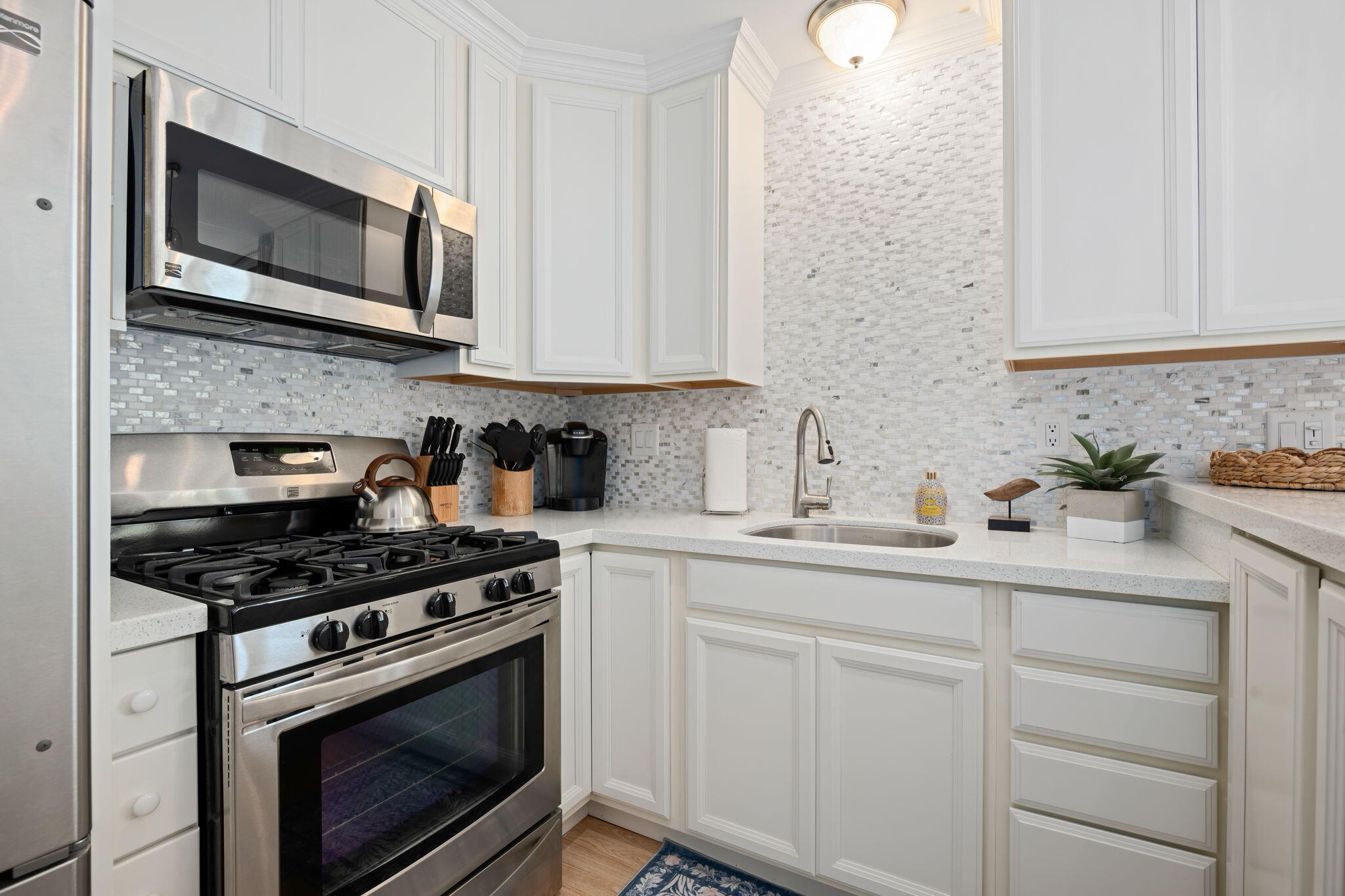 4880 Sandyland Road, Unit 48 Carpinteria, CA 93013 - Photo 11 of 29 a kitchen with white cabinets stainless steel appliances and sink