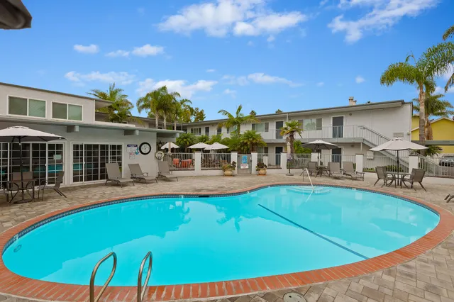 a view of a patio with a table and chairs under an umbrella