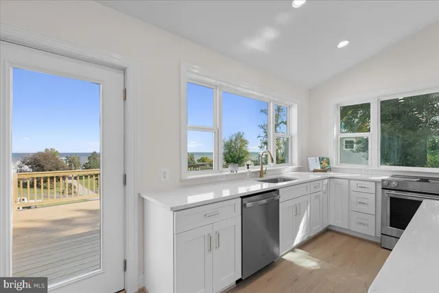a kitchen with a sink stove a refrigerator and cabinets