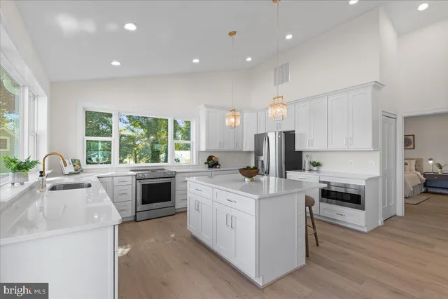 a kitchen with white cabinets and chairs