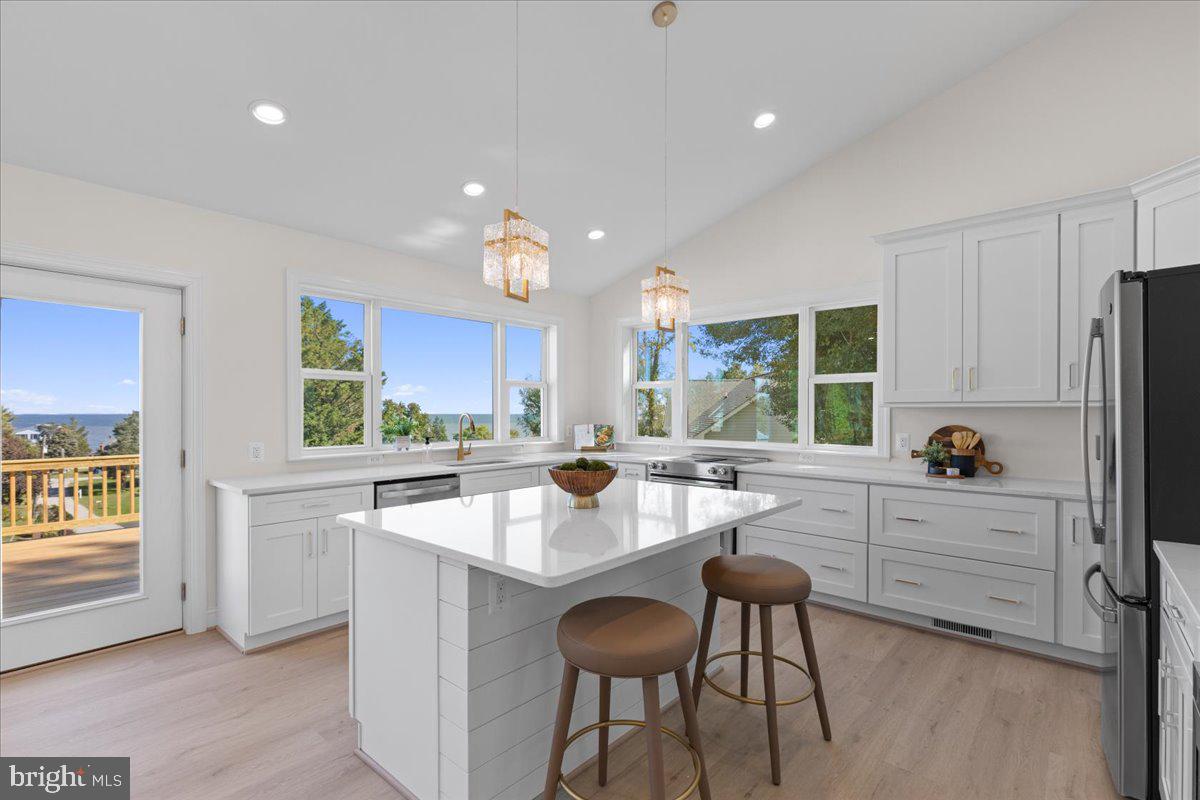 2825 Ridge Road Huntingtown, MD 20639 - Photo 17 of 66 a kitchen with white cabinets and chairs